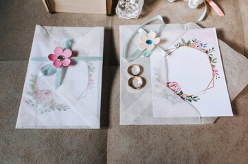 Wedding accessories for the bride: invitation, envelope decorated with flowers, rings. Photography, concept.
