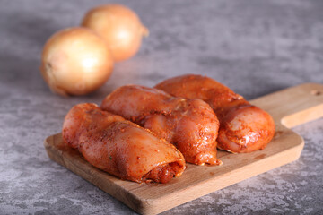 the chicken in the marinade is lying on the board