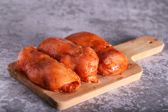the chicken in the marinade is lying on the board