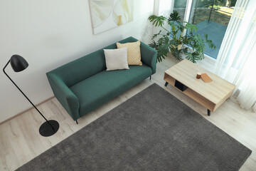 Living room interior with soft grey carpet and modern furniture, above view