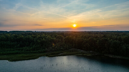 Aerial view of a rural landscape during sunrise in Belgium. Rural farm, corn fields, green fields, sunlight and fog. Belgium, Europe. High quality photo