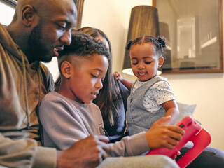 Parents with son and daughter playing at home