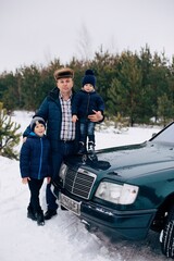 Dad with two sons in the winter forest
