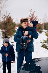 Fototapeta na wymiar Dad with two sons in the winter forest 