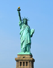 Statue of Liberty, colossal neoclassical sculpture on Liberty Island against blue sky. New York...