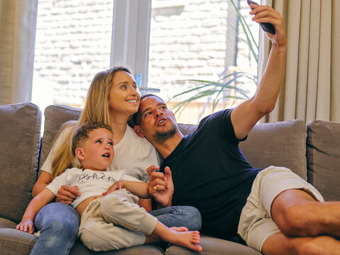 Family With Son Taking Salfie On Sofa