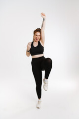 Smiling young plus size fitness woman in sportswear