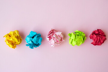 crumpled color papers on pink background with blank copyspace