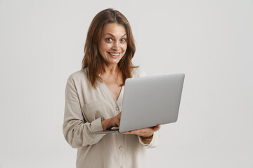 European ginger woman smiling while using laptop