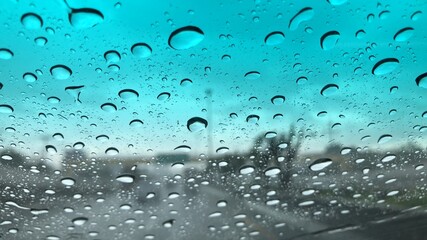 Rain falling on car windshield,drive car on street in city at heavy rain storm,selective focus.