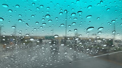 Rain falling on car windshield,drive car on street in city at heavy rain storm,selective focus.