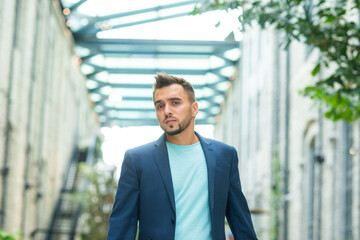 A young successful businessman is working outdoor using smartphone. Man in a casual wear. Business, freelance and remote work.