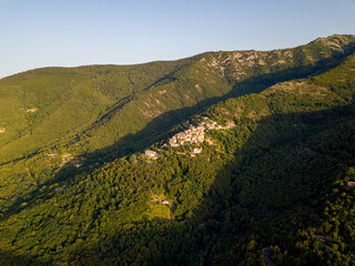 Fototapeta premium Aerial Drone Panorama of mountain old town Marciana on the islands of Elba Italy with green trees and the mediterranean sea ocean in the background