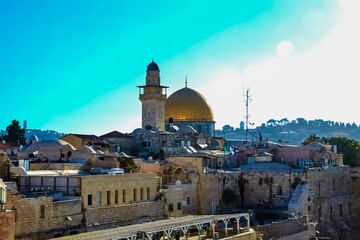 Fototapeta na wymiar Al-Ghawanimah Minaret (Bani Ghanim Minaret), Dome of the Rock, Temple Mount, and the ancient rooftops of the old city of Jerusalem, Israel. on a sunny day