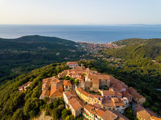 Fototapeta na wymiar Aerial Drone Panorama of mountain old town Marciana on the islands of Elba Italy with green trees and the mediterranean sea ocean in the background