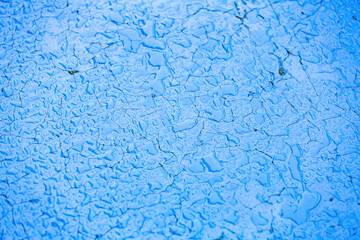 Bright blue surface with water drops and morning dew after rain