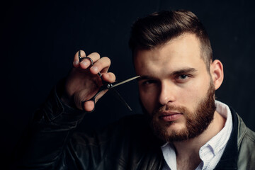 Young sexy man, portrait of guy with barber scissors for barber shop. Modern barbershop, shaving. Handsome male with modern hairstyle on black.