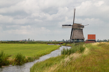 Windmill - De Woudaap, an octagonal thatched inner polder mill in Krommeniedijk, the Netherlands.
