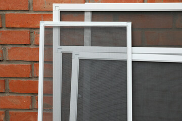 Set of window screens near brick wall