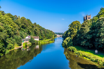 Fototapeta na wymiar A view down the River Wear towards western bank in Durham, UK in summertime