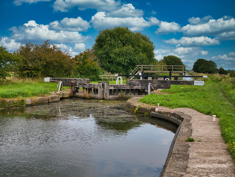 Moss Lock (4) and footbridge on the Rufford Branch of the Leeds Liverpool Canal in Lancashire, UK. Taken on a sunny day in summer.