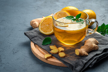 Healthy, warming tea with ginger and lemon on a dark background. A drink that strengthens the...