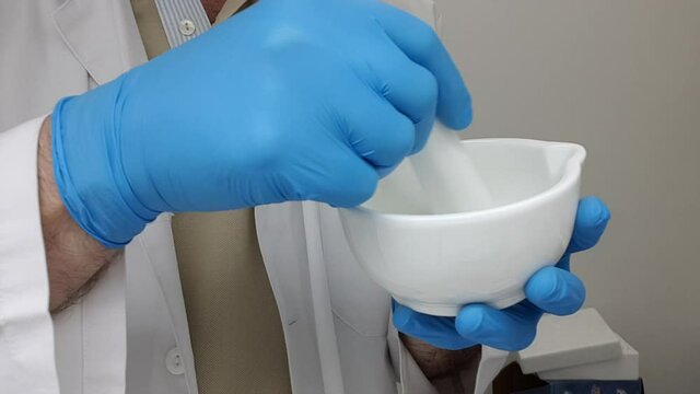 Pharmacist preparing an ointment in the mortar. Manufacture of drugs in the prescription laboratory