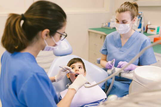 Dentists curing teeth of patient with dental drill