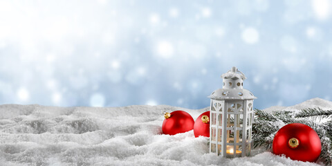 Christmas lamp on snow and red balls decoration. 