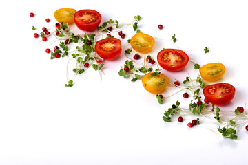 Composition of red and yellow cherry tomatoes with microgreens and pink pepper on a white background, isolated