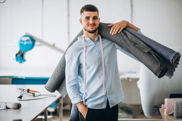 Man cutter at a sewing factory holding fabric