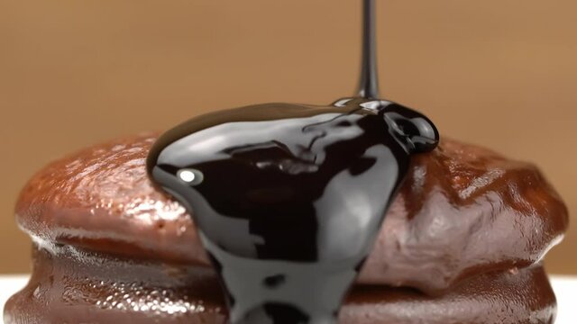 Closeup view of pouring chocolate syrup on homemade choco pie, delicious cho co pie fileed with marshmallow.