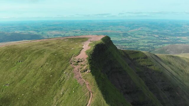 Aerial drone shot of hikers atop Pen Y Fan and Cribyn mountain peaks in Brecon Beacons National Park, Wales