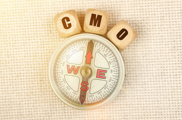 On the table is a compass and cubes with the inscription - CMO
