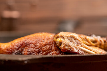 Pieces of roast duck with spices in a frying pan, close-up, selective focus.