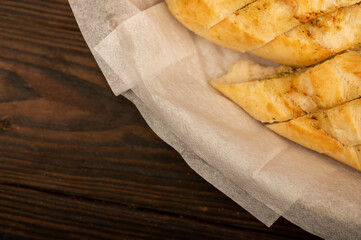 Baguette with garlic paste cut into pieces, close-up, selective focus.