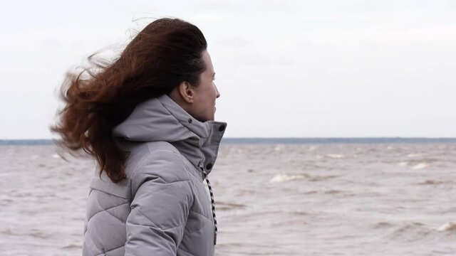 A Woman Looks at the Foamy Waves. Windy Autumn Day at the Shore of Lake Ilmen.