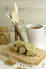 Sunflower halva on wooden board, seeds in a glass jar, cup of tea. Traditional estern europe dish
