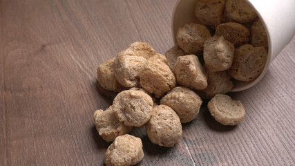 Raw soya chunks on dark background. Healthy, nutritious soybean meat, chunks isolated.Vegan food concept.