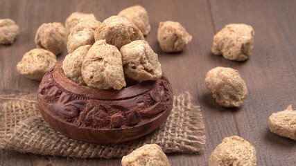 Raw soya chunks on dark background. Healthy, nutritious soybean meat, chunks isolated.Vegan food concept.