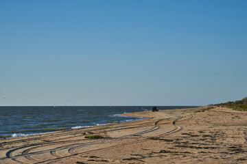 Fototapeta na wymiar Image of the sea shore. The car is driving along the seashore.