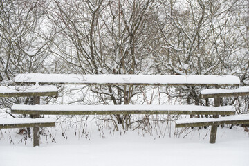 Wooden fence in the snow on winter country background
