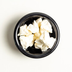 Plato peque&ntilde;o con queso crema servido en cubos en vista superior