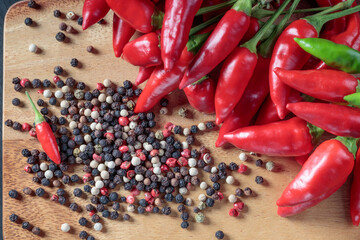 Top view of chili pepper and red, black, white peppers on a wooden background. Soft focus.