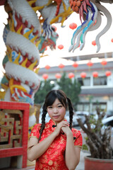 beauty woman wear red cheongsam looking and smile in chinese new year