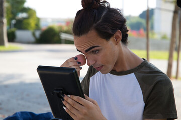 young latina transsexual woman is in a park where she is going to start doing her make-up for her big change from boy to girl. Concept of diversity, transgender, and freedom of homosexual expression.