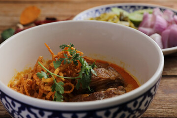 Local northern Thai food Egg noodle curry with pork ribs on wood background