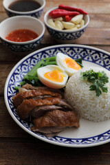 Local Thai food stewed pork leg on rice isolated in wood background