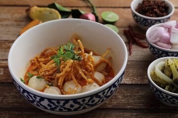 Local northern Thai food Egg noodle curry with meatballs on wood background