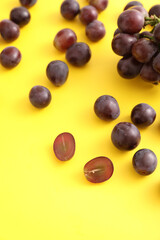 Red grapes isolated in yellow background